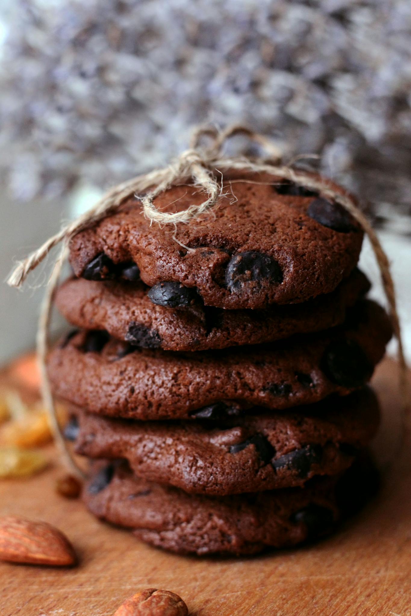 Delicious stack of chocolate chip cookies tied with string on a wooden board.