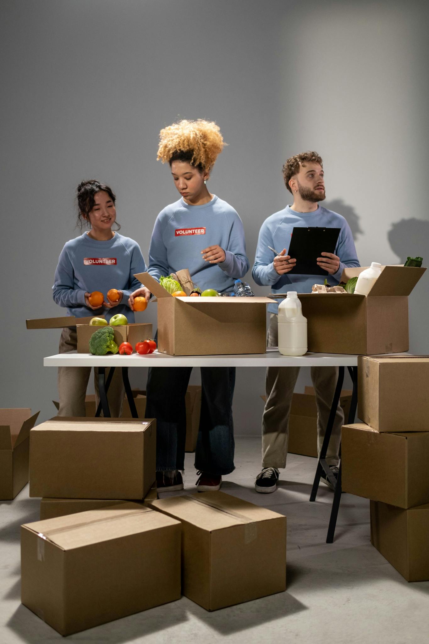 Diverse group of volunteers organizing food donations indoors.